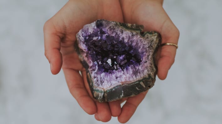 woman holding purple crystal in her hands