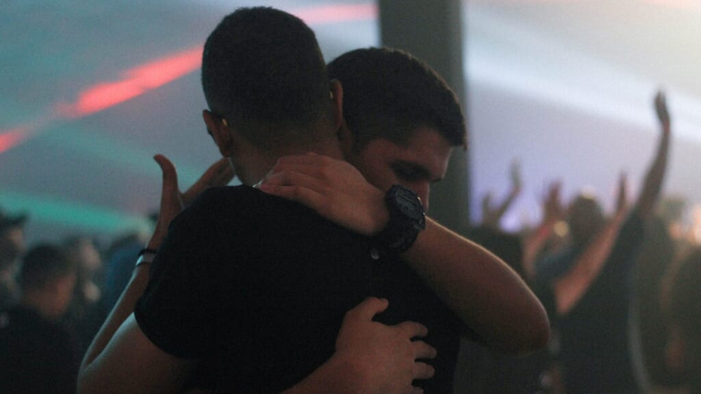 2 men hugging in a crowded room
